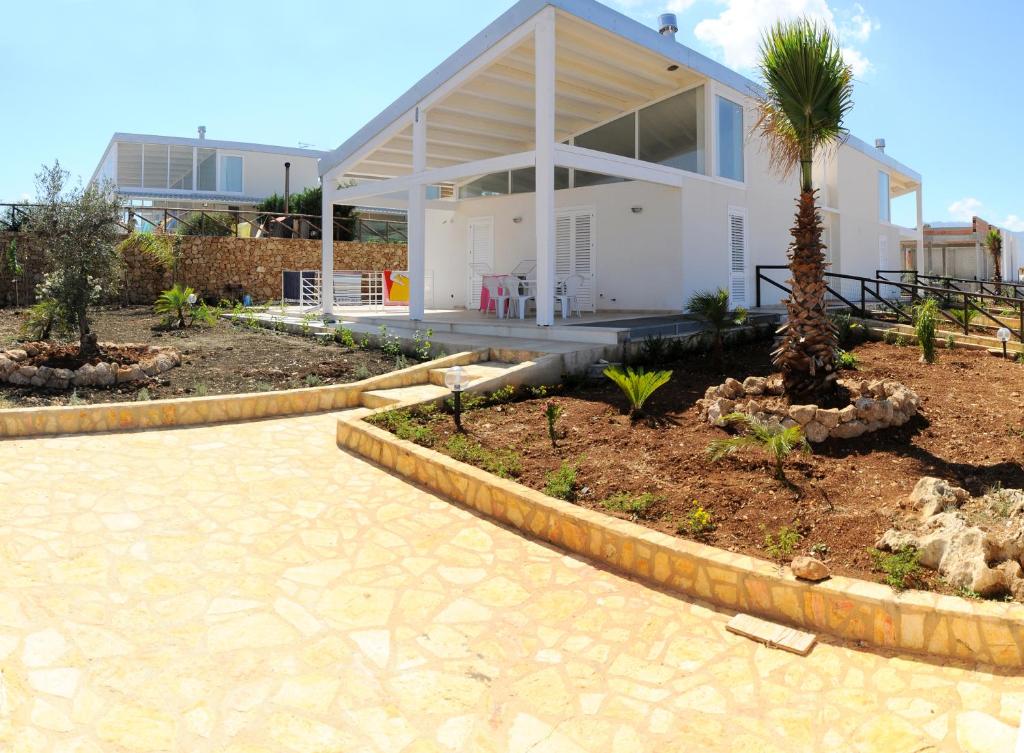 库斯托纳奇紫海度假屋的前面有棕榈树的白色房子