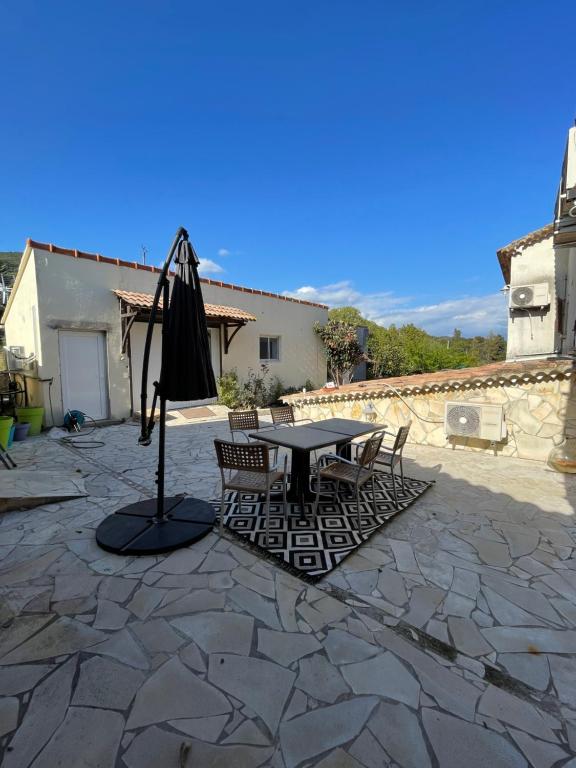 阿雅克修Mont gozzi的庭院配有桌椅和遮阳伞。