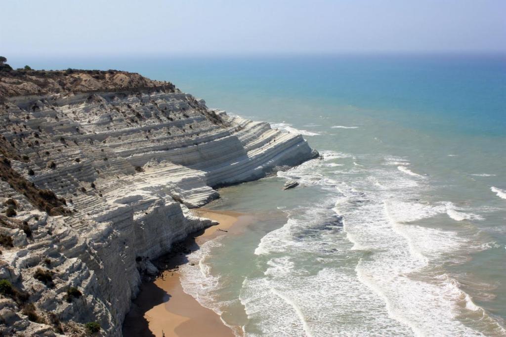 雷阿尔蒙特Baia dei turchi locazione turistica的海洋和岩石海岸线的空中景观