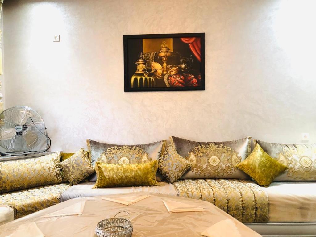 阿加迪尔L impérial appart haut founty的客厅配有带金色枕头的沙发