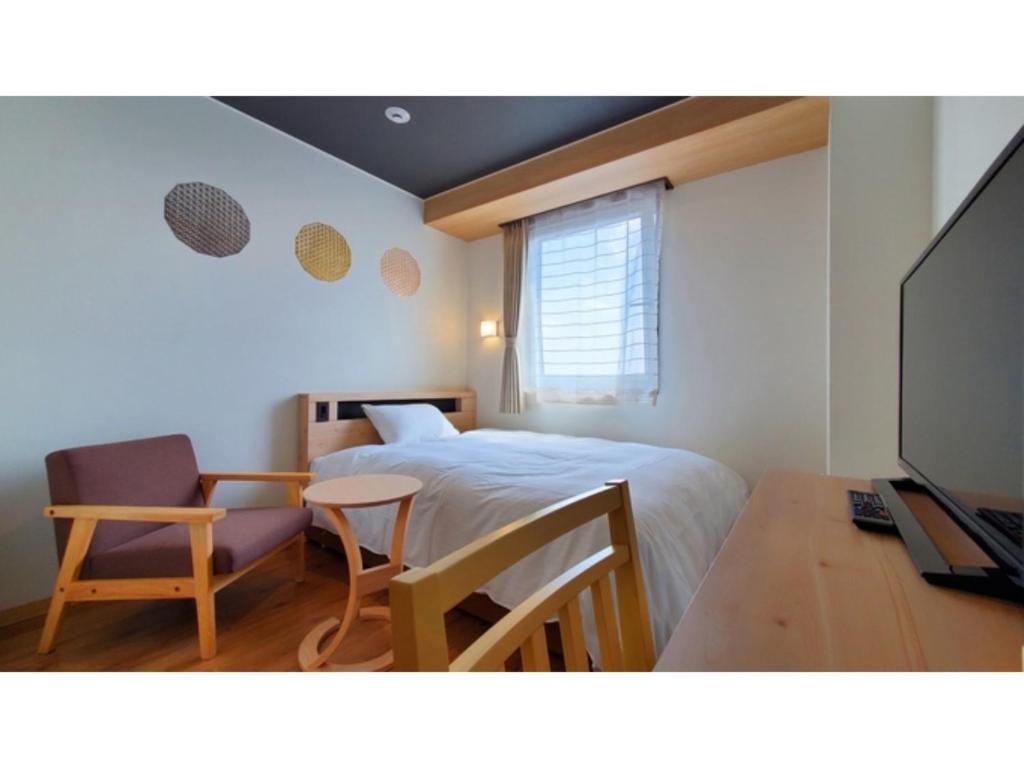 Tochigiｂｕｓｉｎｅｓｓ&ａｃｔｉｖｉｔｙ ｃｈａｎｖｒｅ - Vacation STAY 64311v的一间卧室配有一张床、一张书桌和一台电视