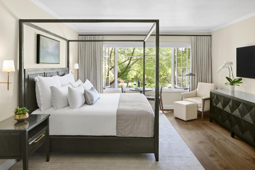 纳帕Milliken Creek Inn的卧室配有一张白色大床、一张书桌和窗户。