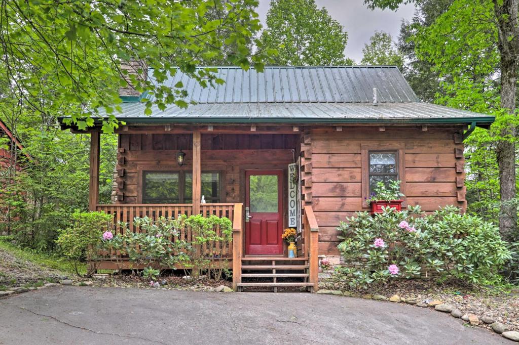 加特林堡Romantic Gatlinburg Cabin with Hot Tub and Pool Access的一间设有红色门的小小木屋