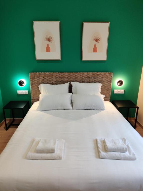拉图迪潘Hôtel de la Tour的一间卧室设有一张白色大床和绿色的墙壁
