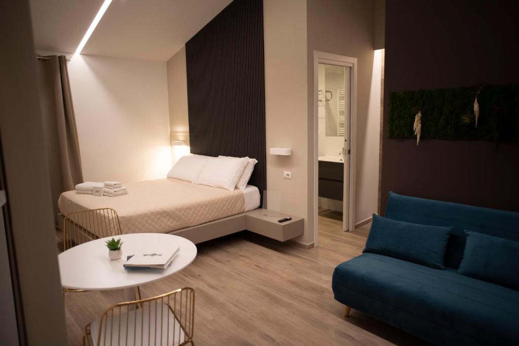 克罗托内House Room Civico 56的小房间设有床、桌子和沙发