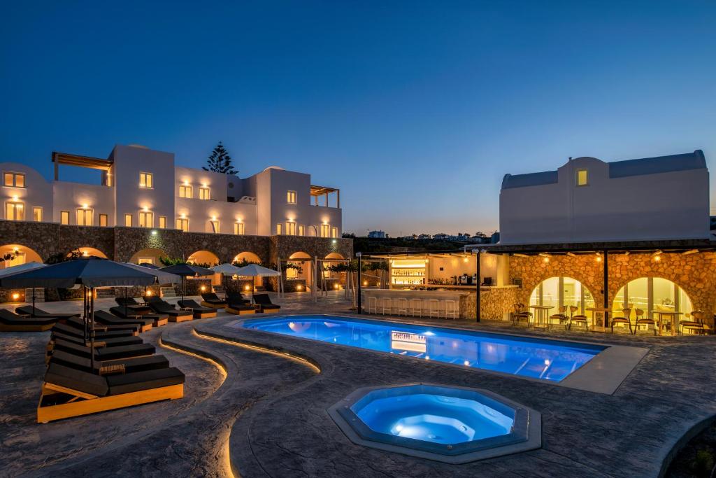 卡特瑞杜斯Aelia Luxury Suites的夜间带游泳池的度假村