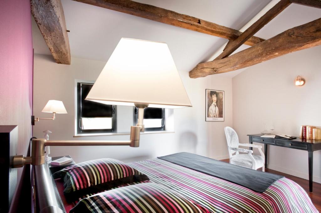 LegéLa Villa des Forges的一间卧室配有一张床,上面有灯