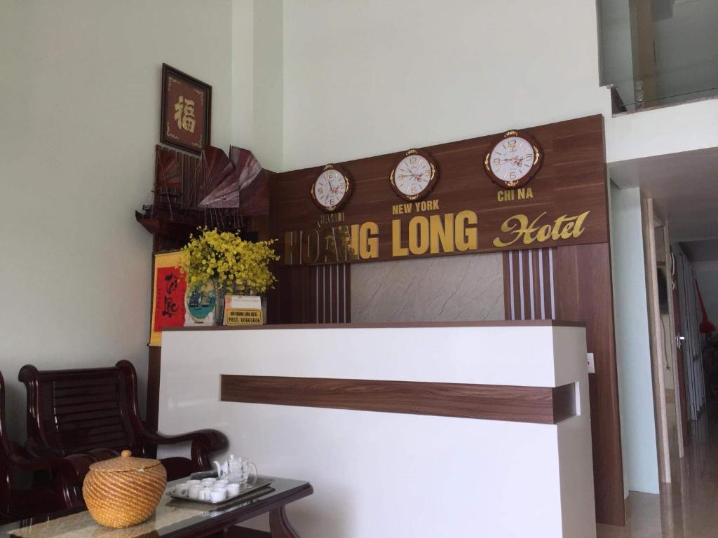 下龙湾Hoang Long Hotel Bai Chay的客厅配有长桌和墙上的时钟