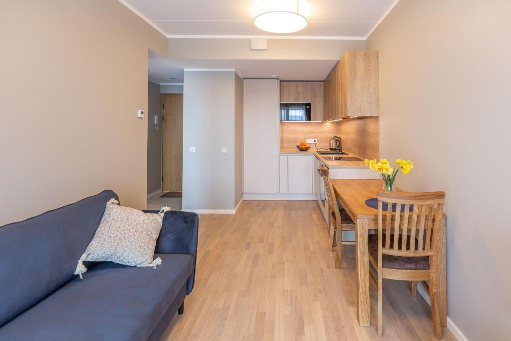 塔尔图Siili Apartment-free parking的一间带蓝色沙发的客厅和一间厨房