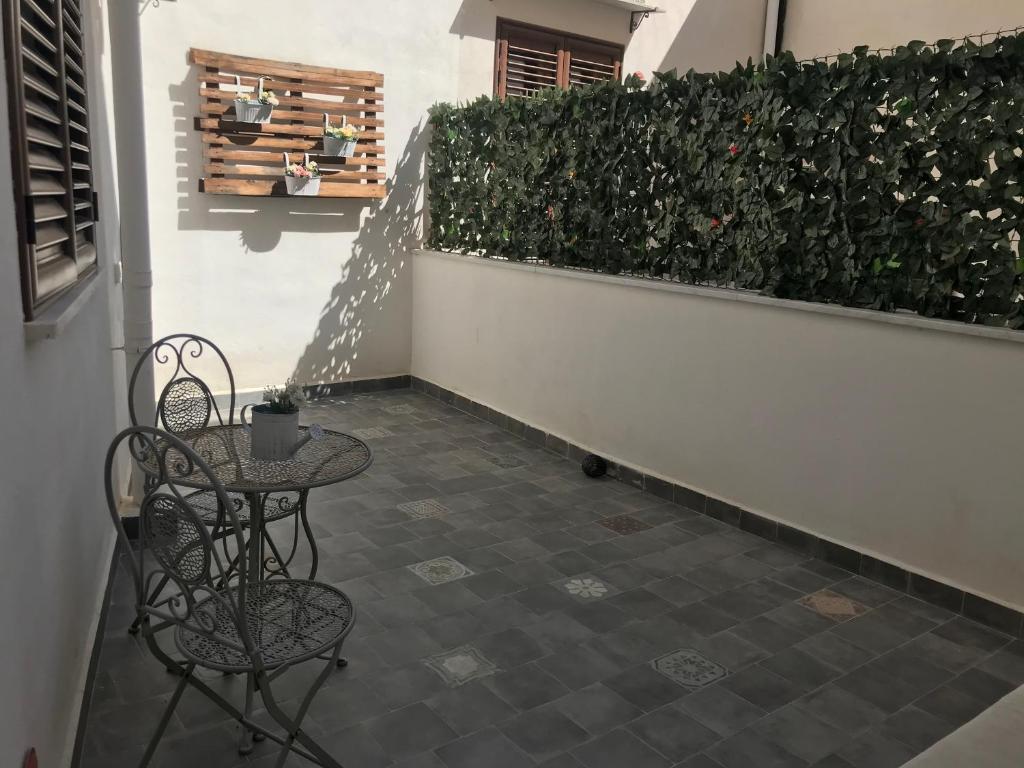 巴勒莫Il mio posto ai Quattro Canti - Centro storico Palermo的庭院设有两把椅子、一张桌子和一条树 ⁇ 