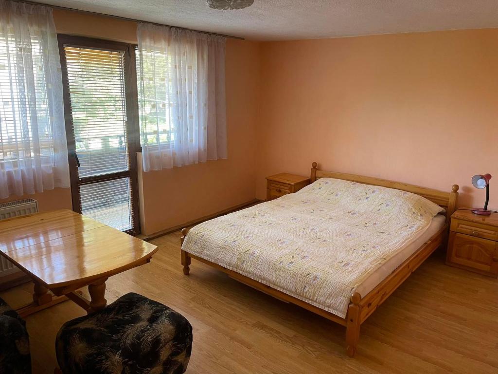 特里亚夫纳Вила Мечта的一间卧室配有一张床和一张木桌