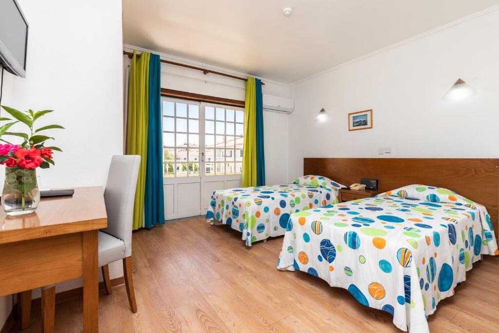 阿尔图拉Hotel Azul Praia的一间卧室配有两张床、一张桌子和一张桌子