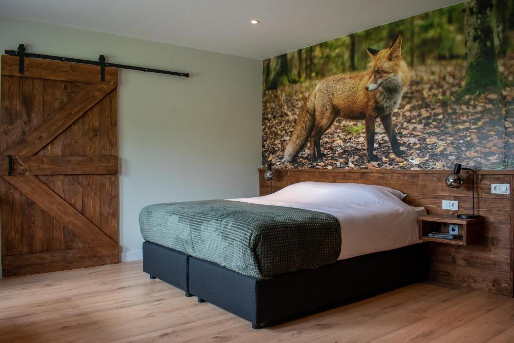 Loon op ZandHotel B&B Buiten Loon的一间卧室配有一张床,画着狐狸