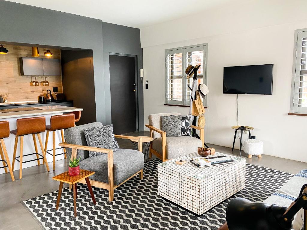 普利登堡湾Stay On Main Plett - Contemporary 2-Bedroom Apartment的带沙发和椅子的客厅以及厨房。