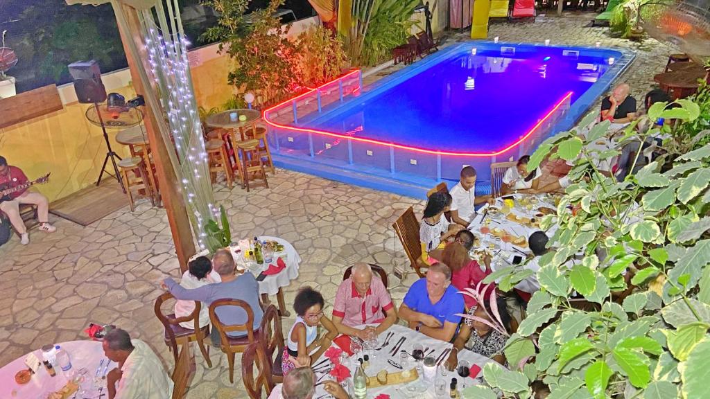 马哈赞加马任加可可酒店及餐厅的一群坐在游泳池前桌边的人