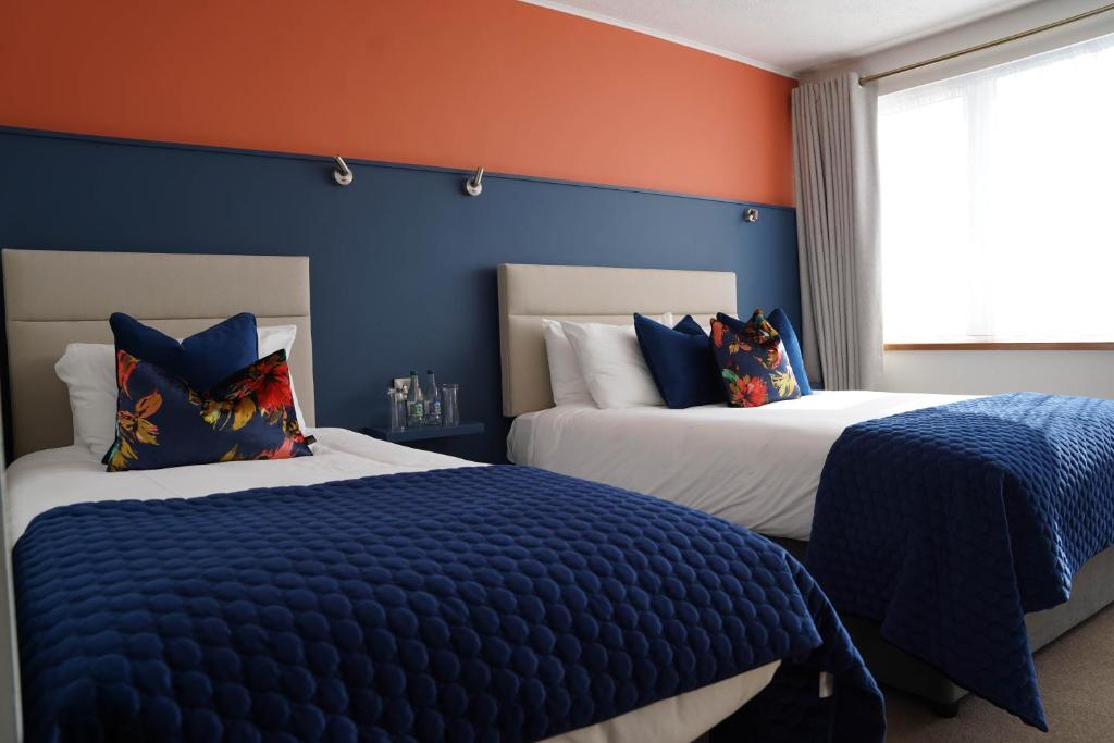 克利夫登欧科克及布朗酒店的卧室设有两张床铺,拥有蓝色和橙色的墙壁