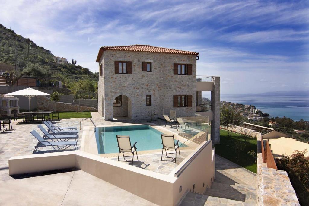 卡拉马塔Villa Dafni的别墅 - 带游泳池和带椅子的庭院