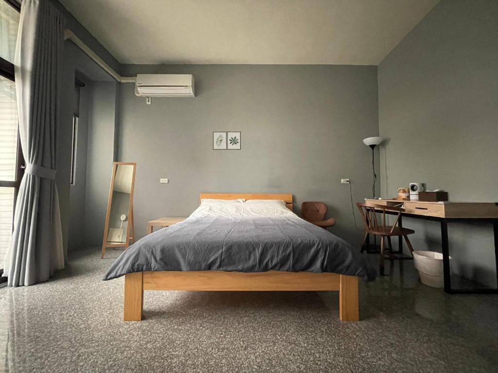 鹿港镇哈楼民宿的一间卧室配有一张床和一张书桌