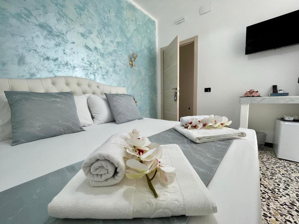 加利波利B&B Poesia的一间卧室配有带毛巾和鲜花的床