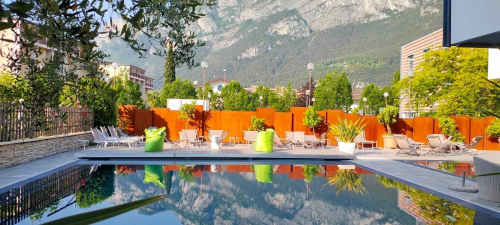 加尔达湖滨维尔吉利奥酒店的一个带桌椅的游泳池以及山脉