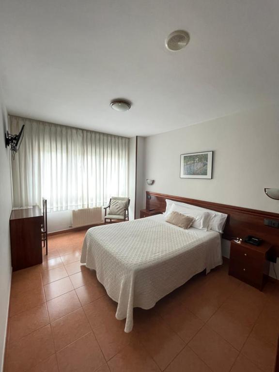 希洪法尔德斯酒店 的卧室配有一张白色大床和一把椅子