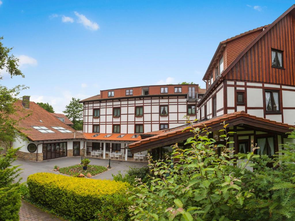 巴特德里堡明镜施瓦林霍夫兰德酒店的一座带红色屋顶和庭院的大型建筑