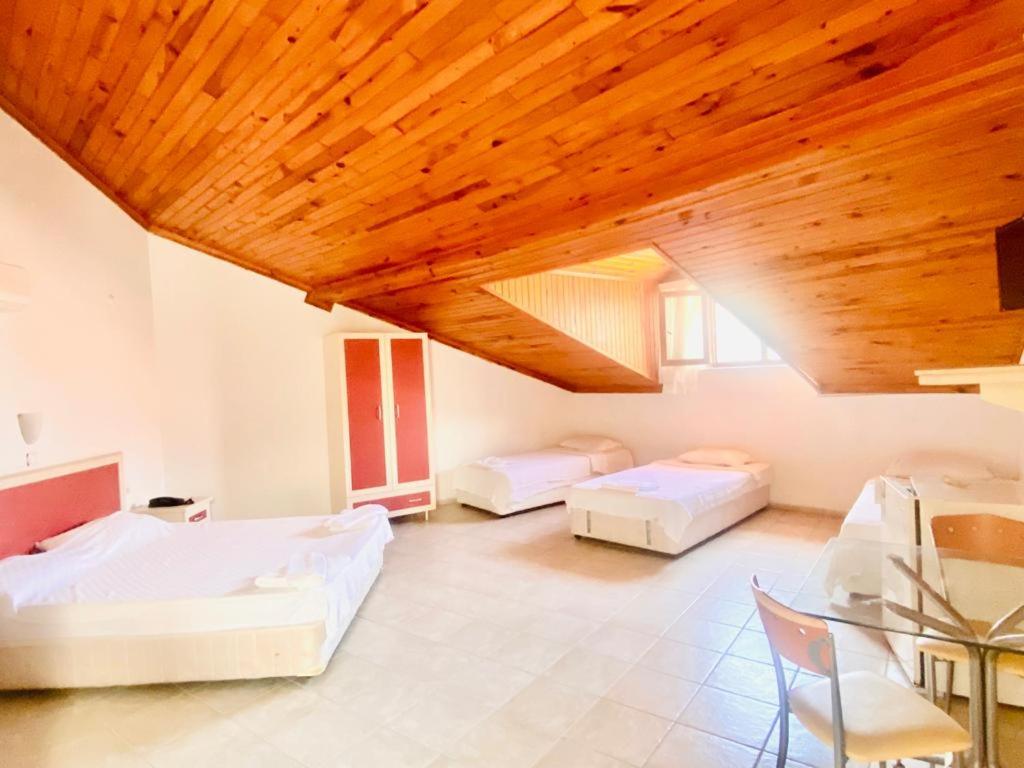 达利安Acar Park Hotel的一间卧室设有两张床和木制天花板