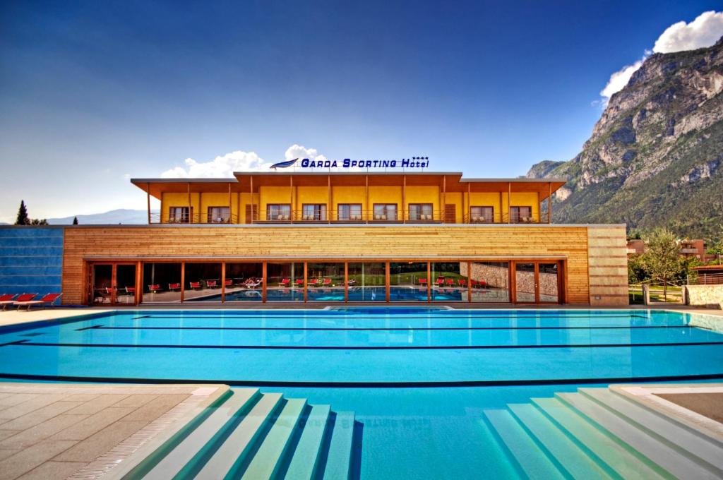 加尔达湖滨加尔达运动俱乐部酒店的大楼前设有游泳池的酒店