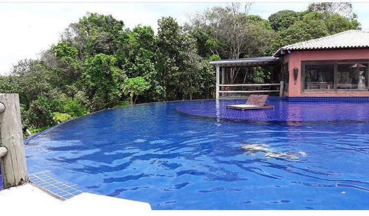 马塞约Villas do Pratagy Temporada Limão的一座房子旁边一大片蓝色的海水