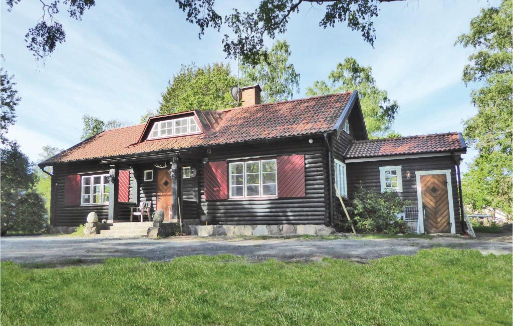 KvicksundStunning Home In Kvicksund With House Sea View的一座红色屋顶的黑色旧房子