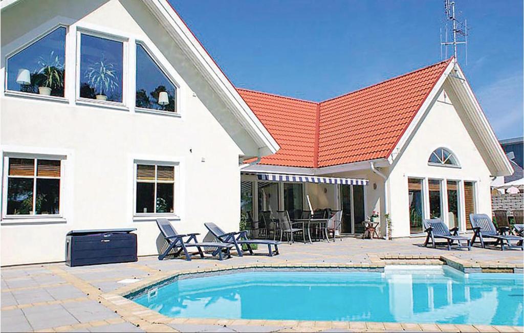 GlemmingeCozy Home In Nybrostrand With Sauna的房屋前有游泳池的房子