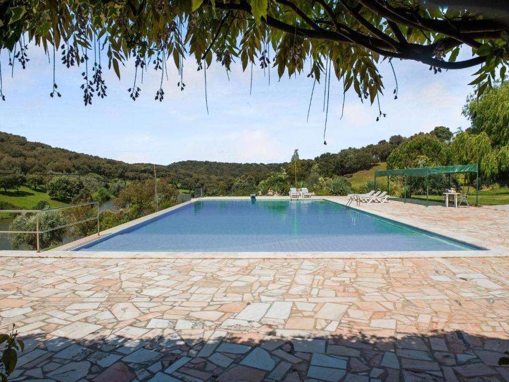 新蒙特莫尔Country mansion in Montemor o Novo Alentejo with shared pool的一座带石头庭院的大型游泳池