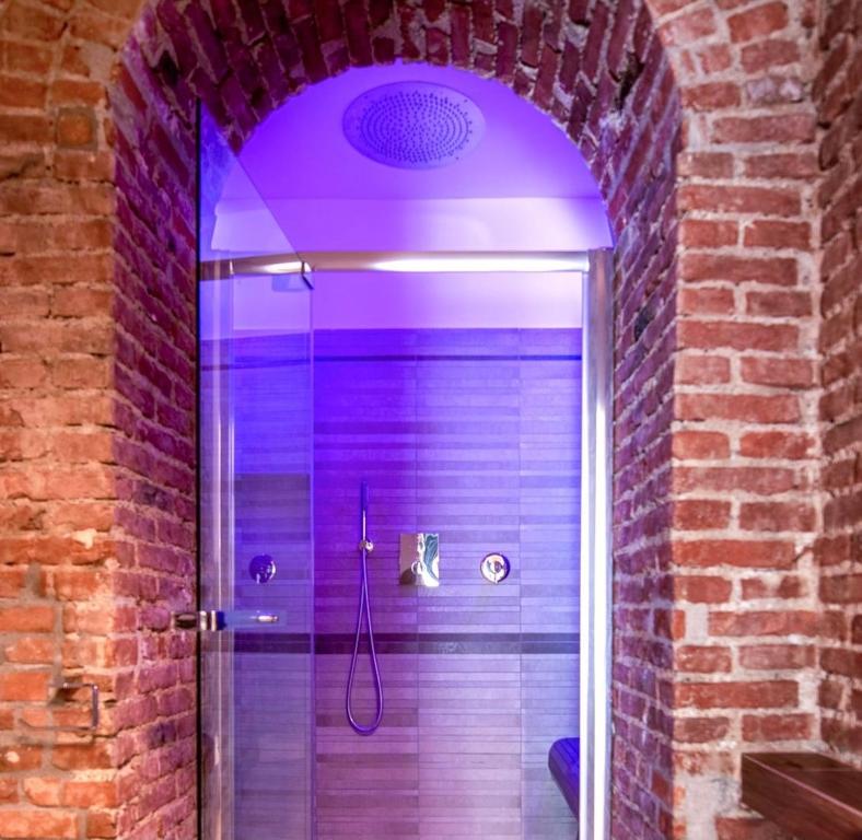 米兰Luxury Apartment in Milan Center的带淋浴的浴室(带紫色照明)