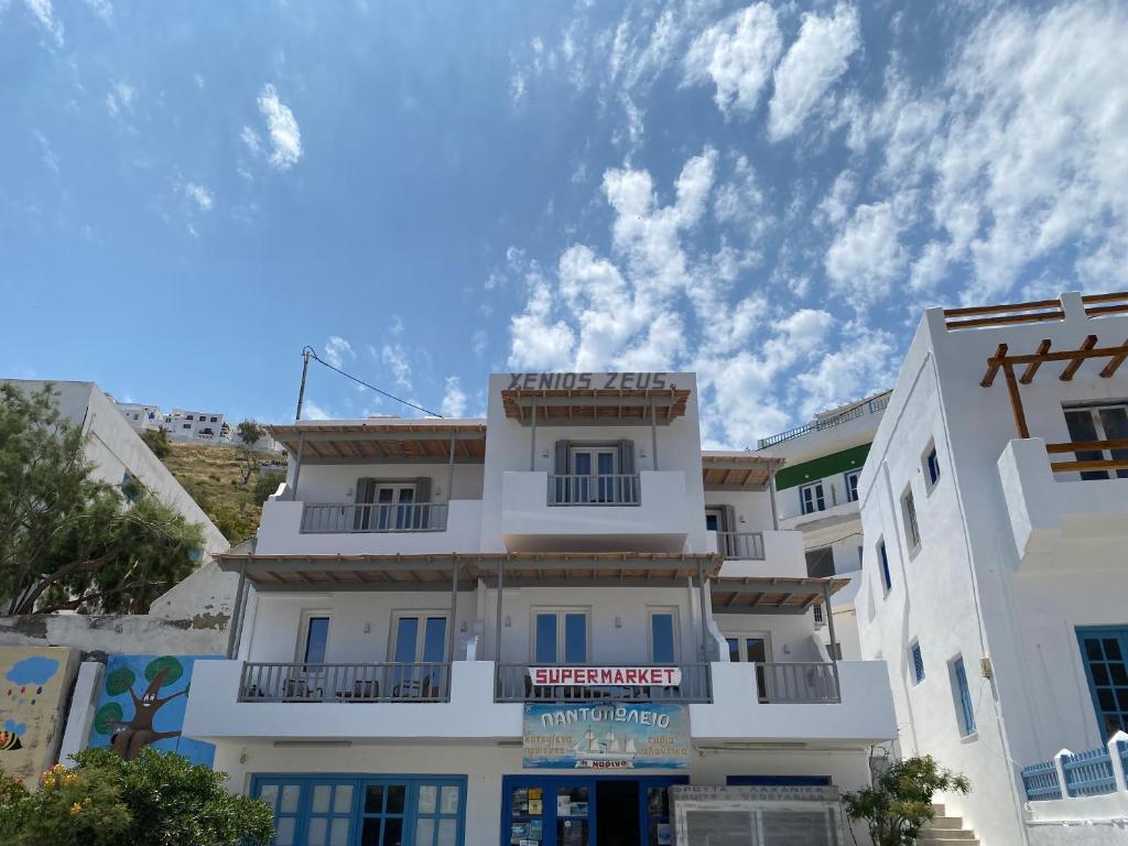 阿斯提帕莱亚镇Xenios Zeus Apartments的前面有标志的白色建筑