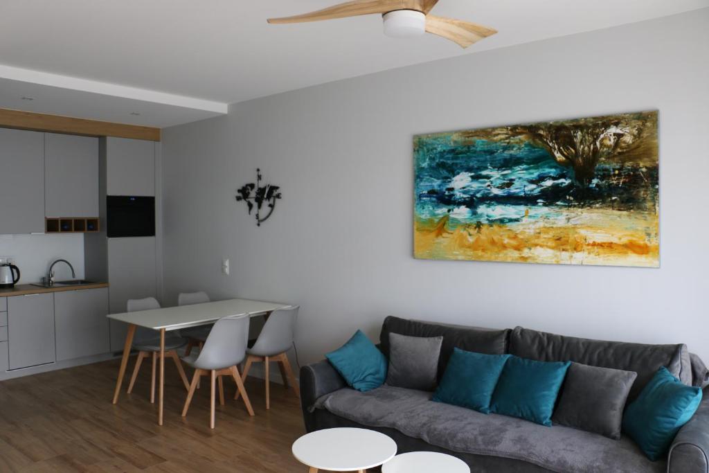 博格泽利卡Turkusowa Liwia的客厅配有沙发和墙上的绘画