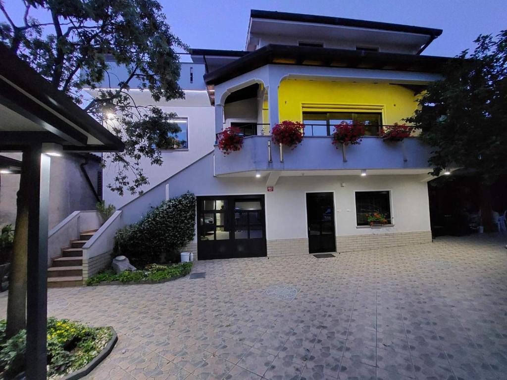 DekaniApartma Mimi的黄色和白色的房子设有阳台