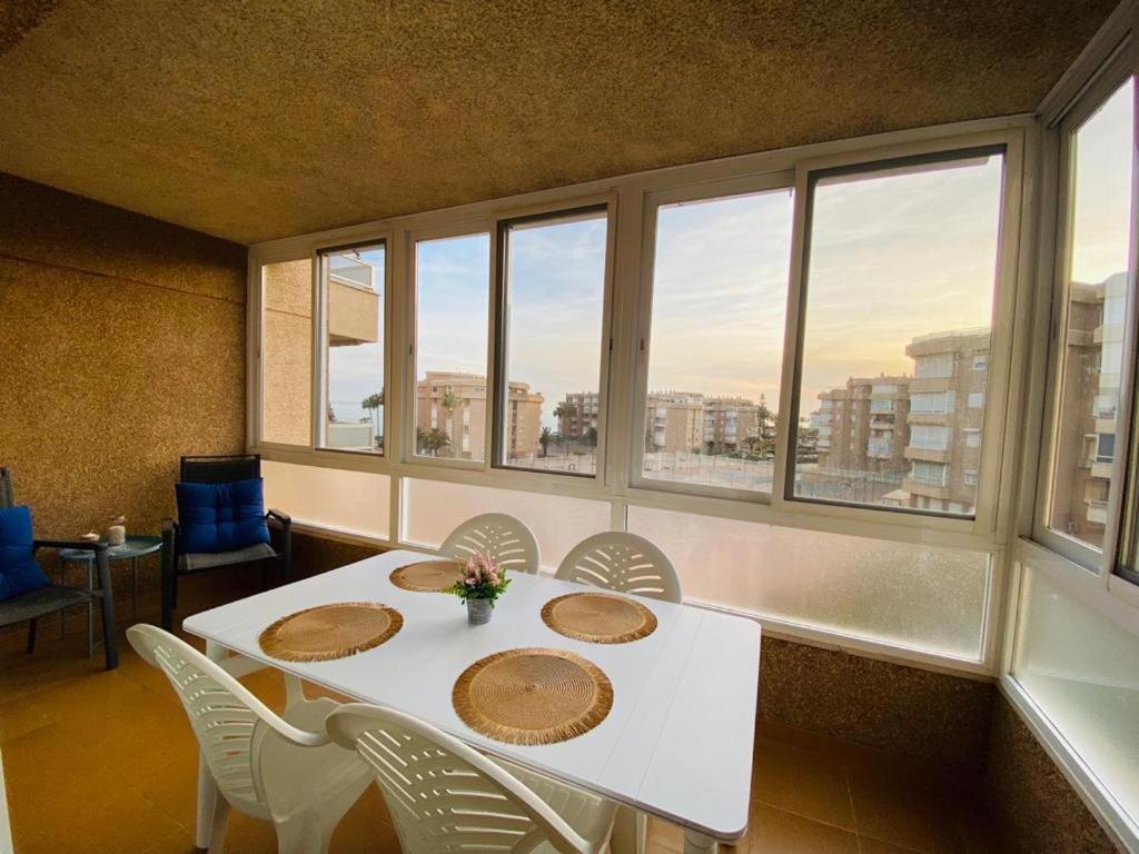 托罗克斯科斯塔Apartamento Arena y Sal的一间设有白色桌子、椅子和窗户的用餐室