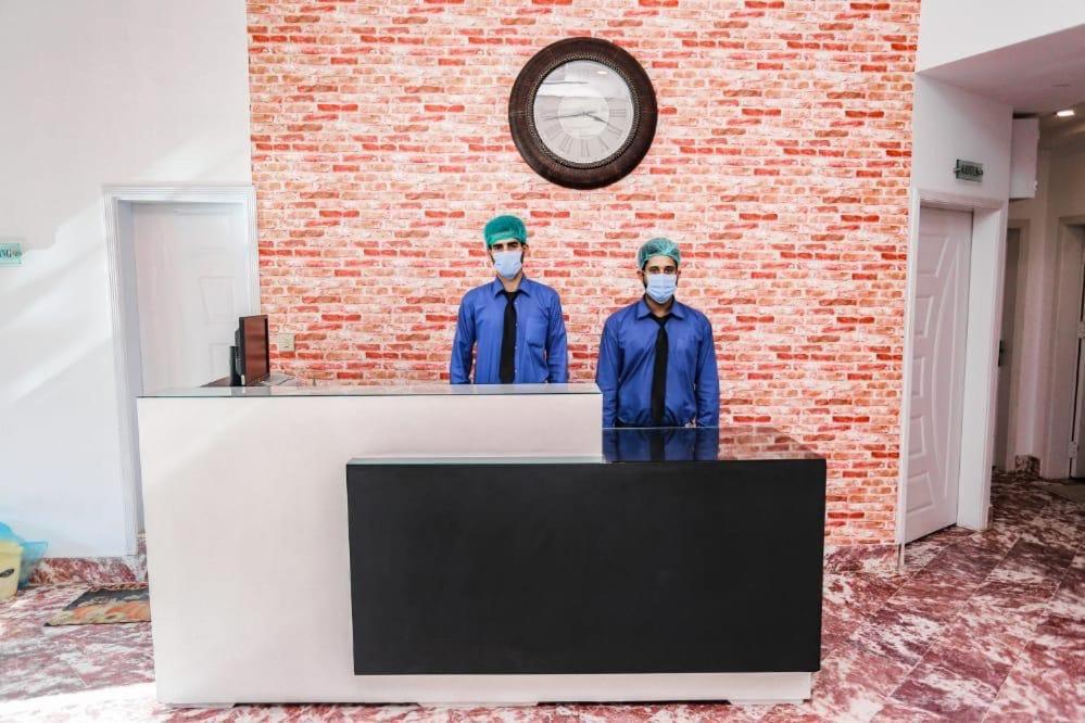 穆扎法拉巴德Thikana Hotel的两个戴面具的男子的雕像站在柜台上