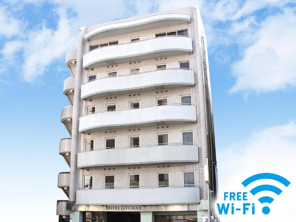 东京HOTEL LiVEMAX BUDGET Tokyo Kiba的一座高大的白色建筑,上面有免费WiFi标志