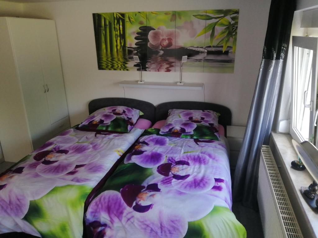 爱尔福特Kleines Apartement zwischen Ega und Messe Erfurt的一间卧室,配有一张紫色花卉床