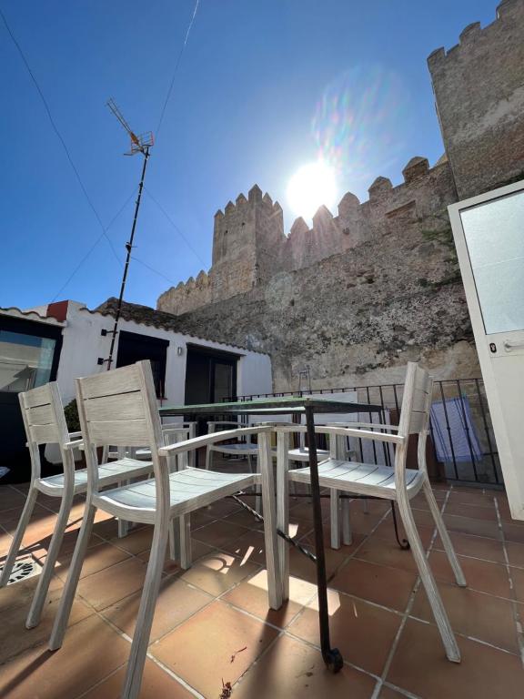 塔里法Apartamentos Tarifa Castillo的一个带城堡的阳台的桌椅