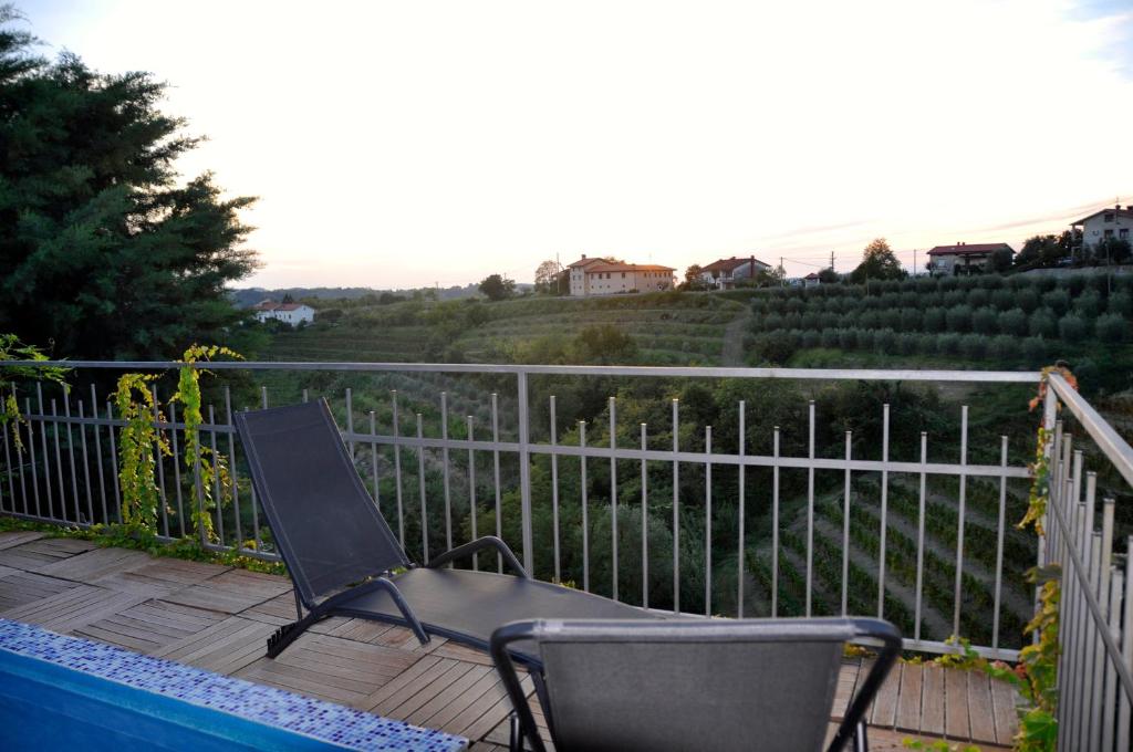 多博沃Apartment in the heart of Brda wine region, Boris and Darinka Marinič的坐在围栏旁甲板上的椅子