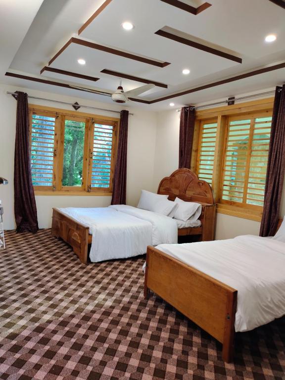 锡卡都PYRAMID LODGE的一间卧室设有两张床、窗户和格子天花板