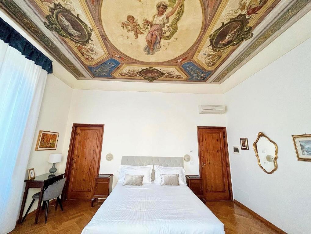 佛罗伦萨奇马布耶9B&B酒店的一间卧室设有一张大床,天花板上装饰有绘画作品