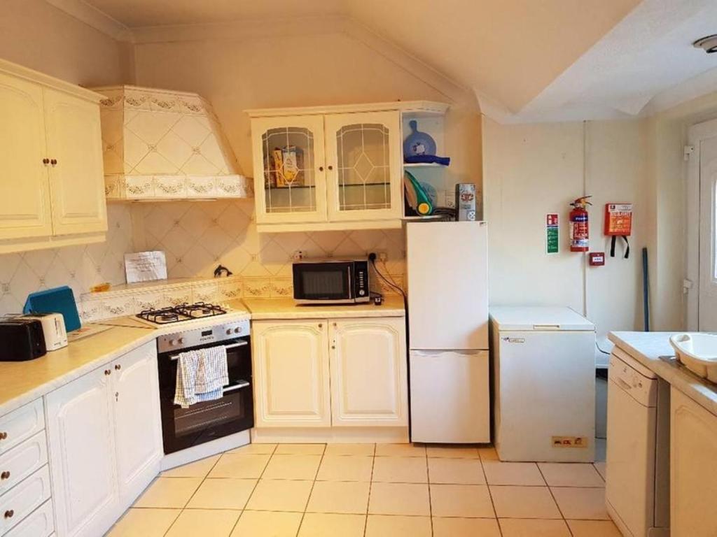 Hebburn-on-TyneThe Hebburn Great House的厨房配有白色橱柜和白色冰箱。