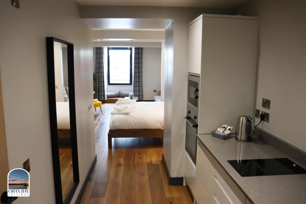 奥本Oban Bay Apartments的一间厨房和一间带一张床的卧室