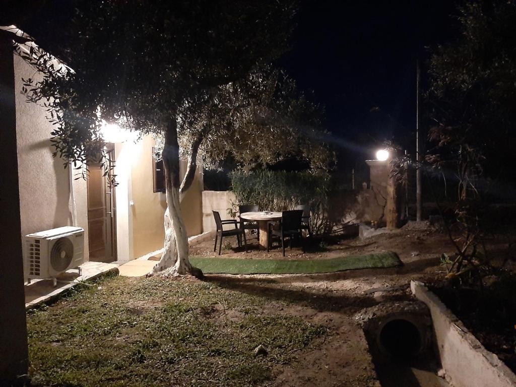 KanakádesTerezina wood house的夜晚带桌子和一棵树的后院