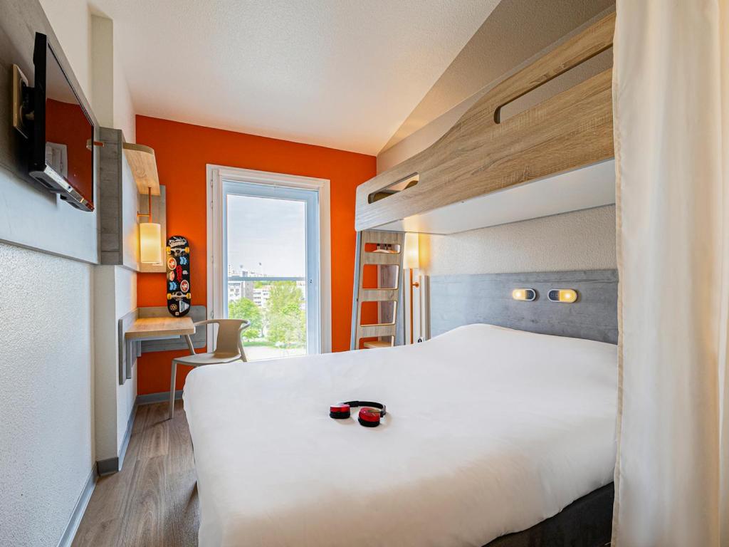 莱克朗兰比塞特尔宜必思巴黎意大利门西部快捷酒店的酒店客房,设有白色的床和橙色的墙壁