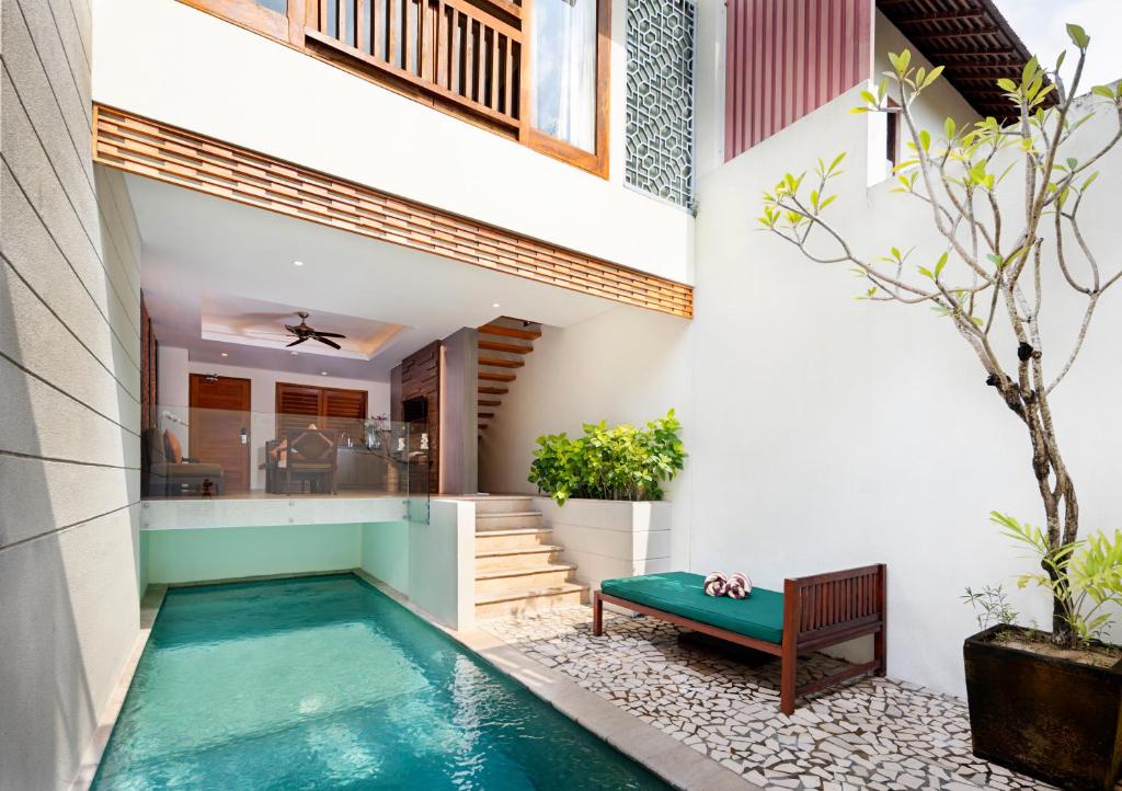 塞米亚克卡玉拉伽别墅酒店的房屋中间的游泳池,带长凳