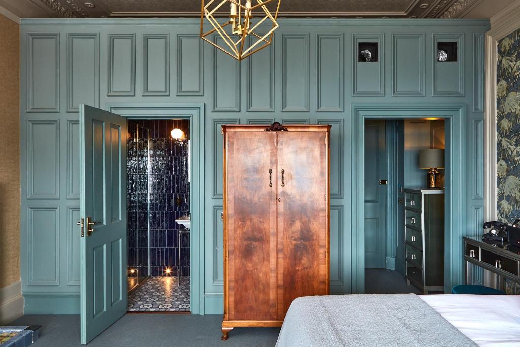 奥本No17 The Promenade的一间卧室设有蓝色的墙壁和木门。
